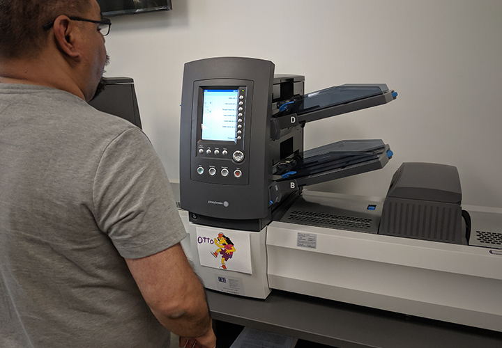 Image of Production Team member loading the folding machine.